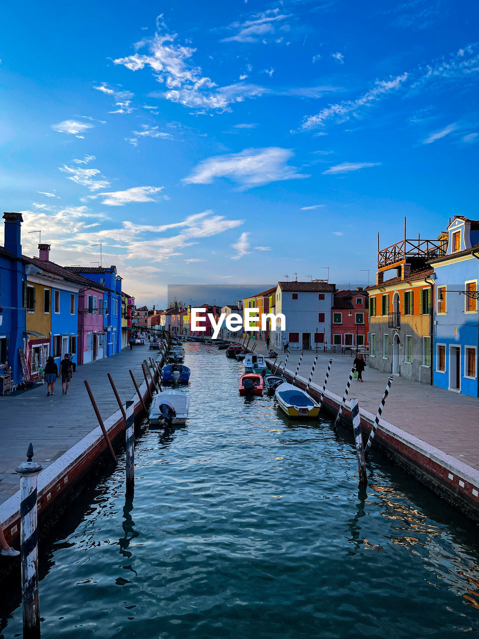 BOATS IN CANAL AMIDST BUILDINGS AGAINST SKY