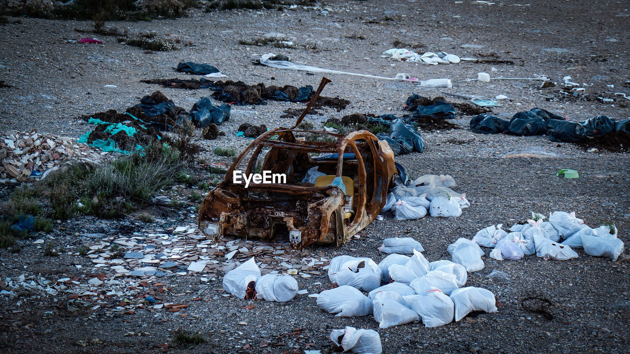 HIGH ANGLE VIEW OF ABANDONED GARBAGE ON THE BEACH