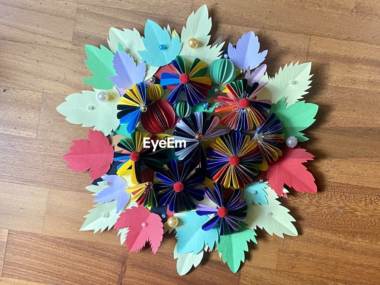 multi colored, high angle view, origami paper, wood, flower, wheel, directly above, table, origami, petal, indoors, creativity, art, no people, art paper, craft, still life, paper, close-up, variation, large group of objects, arrangement, decoration, pattern, hardwood floor