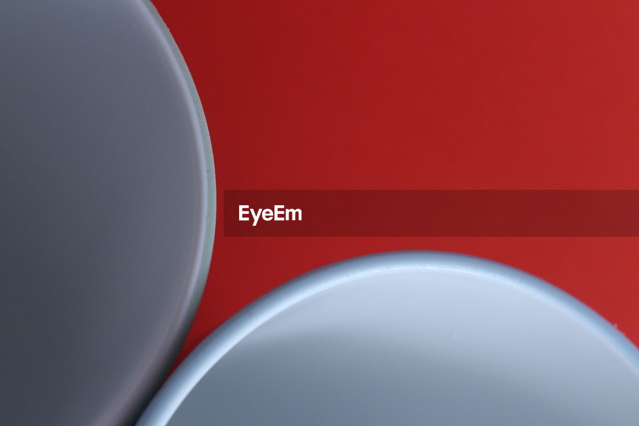 HIGH ANGLE VIEW OF RED LIGHT ON TABLE AGAINST WHITE BACKGROUND