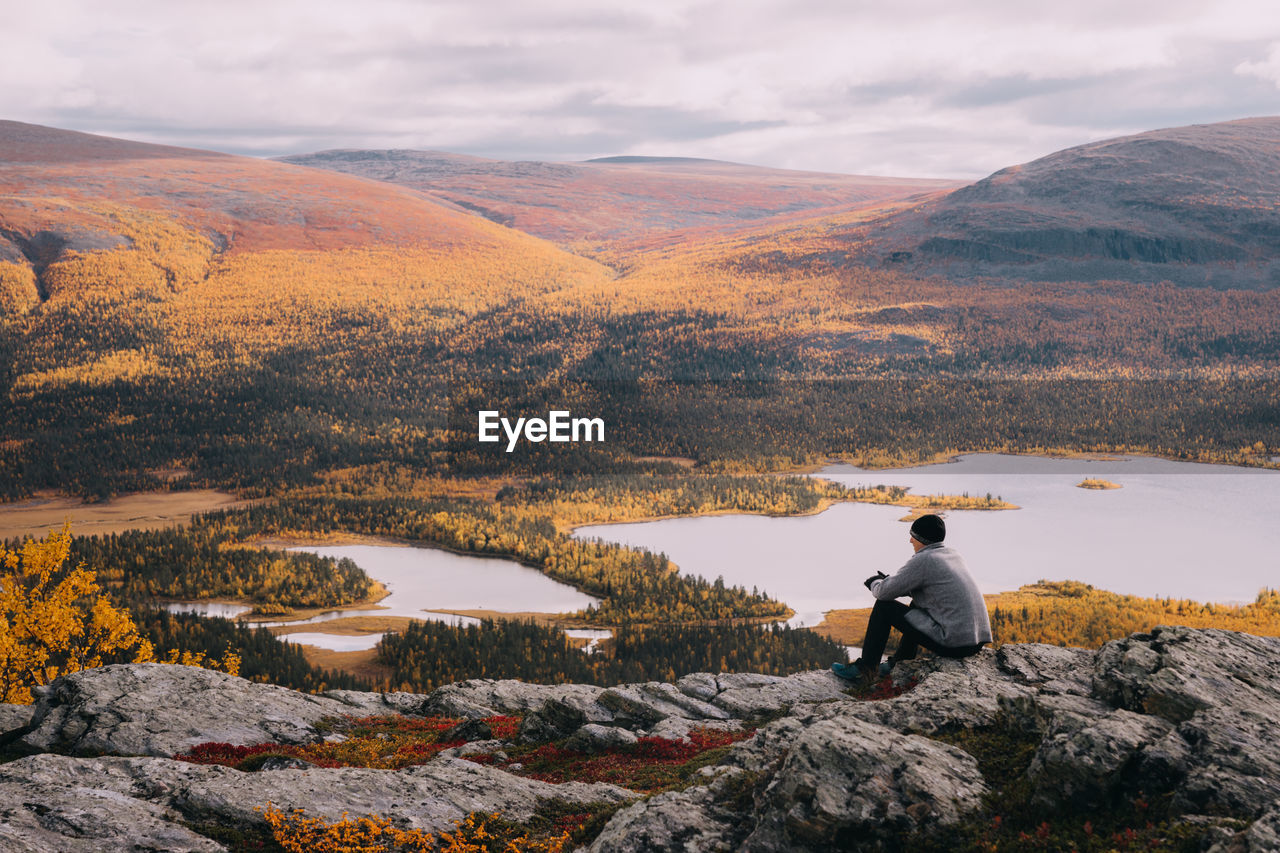Man looking at lake against mountain range