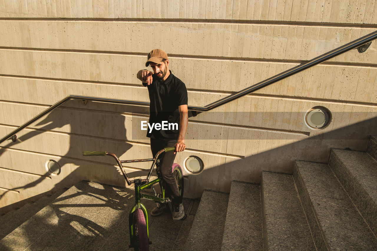 MAN WITH BICYCLE ON STAIRCASE