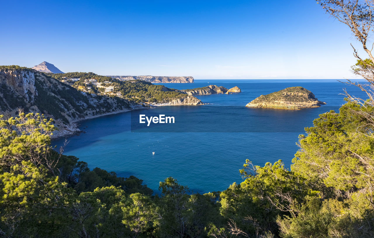 Scenic view of bay against clear blue sky