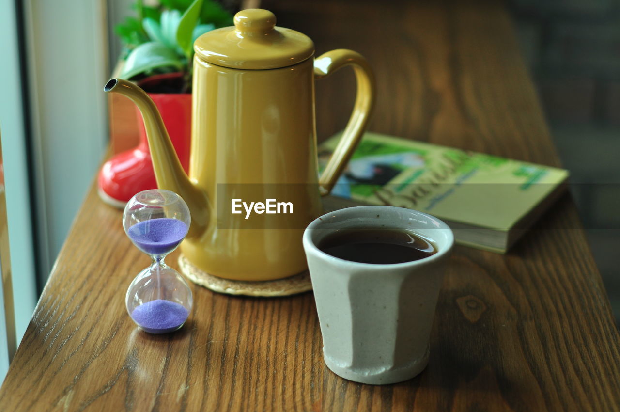 CLOSE-UP OF COFFEE CUP AND TEA ON TABLE