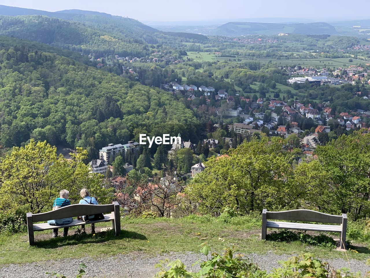 EMPTY BENCH IN PARK AGAINST MOUNTAINS