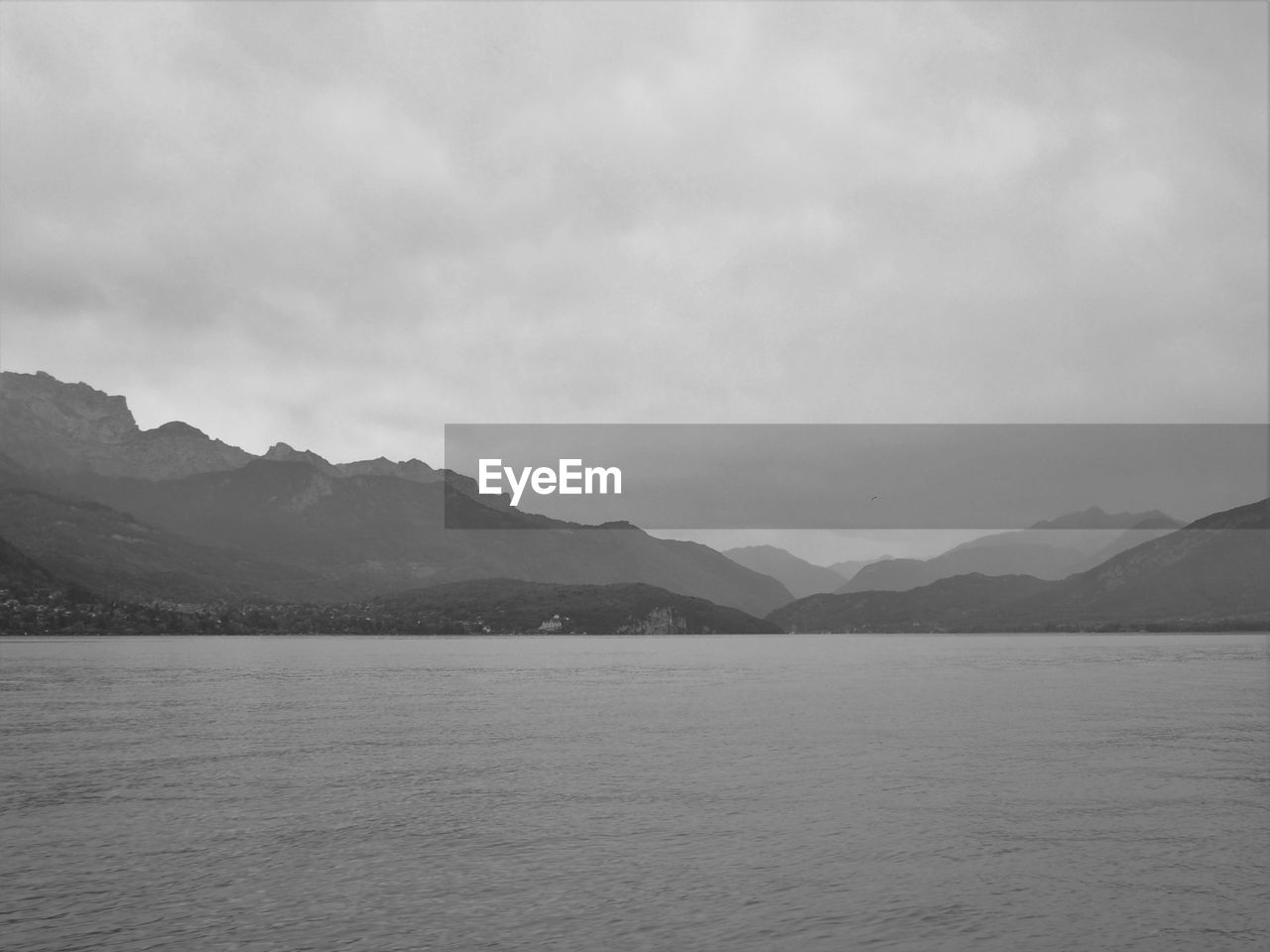 Scenic view of lake against cloudy sky