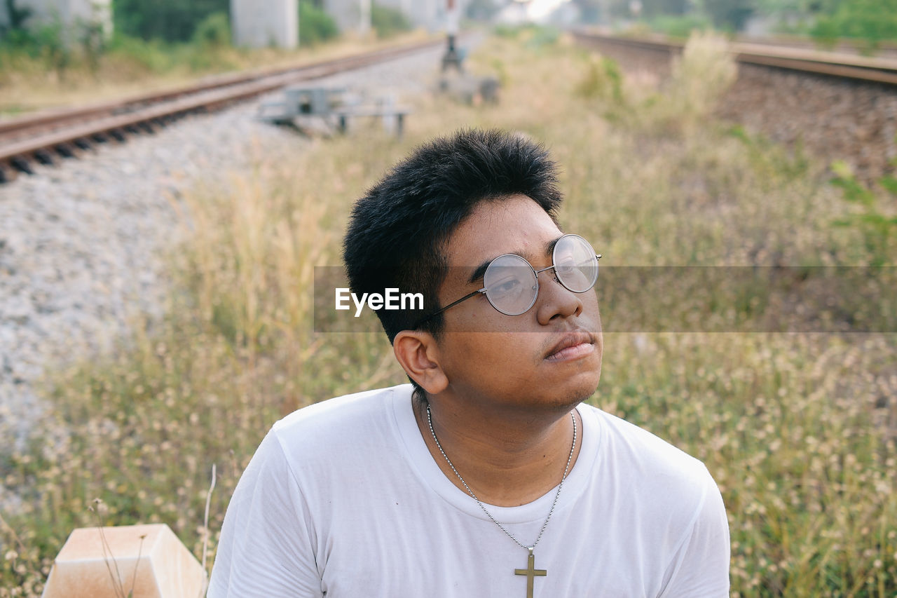 Close-up of thoughtful young man sitting outdoors