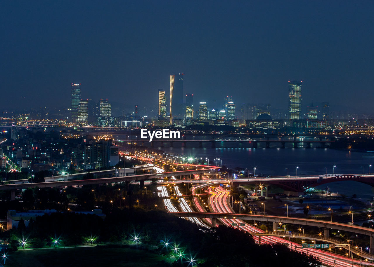 Illuminated cityscape against sky at night