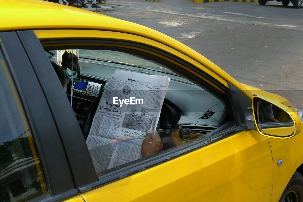 REFLECTION OF MAN ON CAR WINDOW