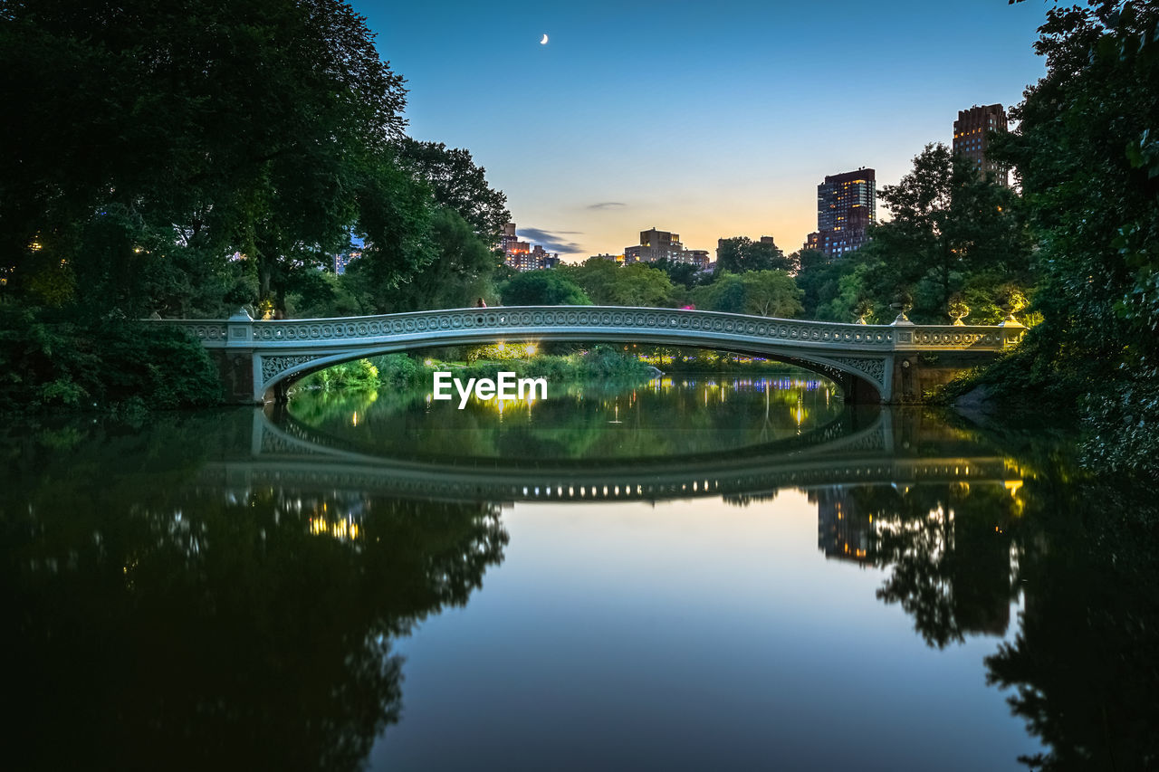 Reflection of bridge in water against sky