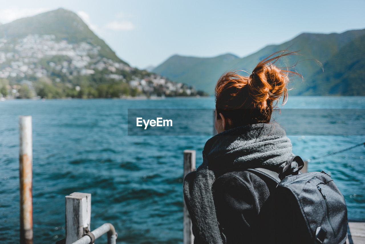 Rear view of woman in lake against mountains