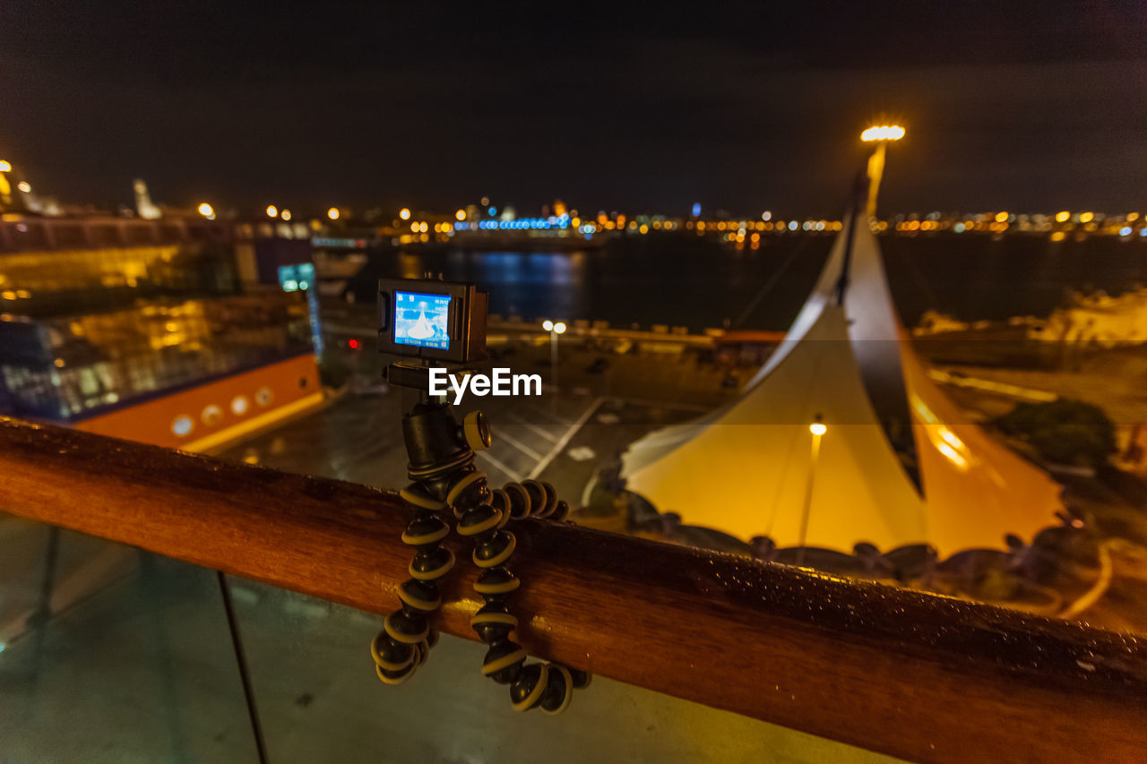 Action camera on tripod that takes over the port of bari at night from the balustrade of a ship