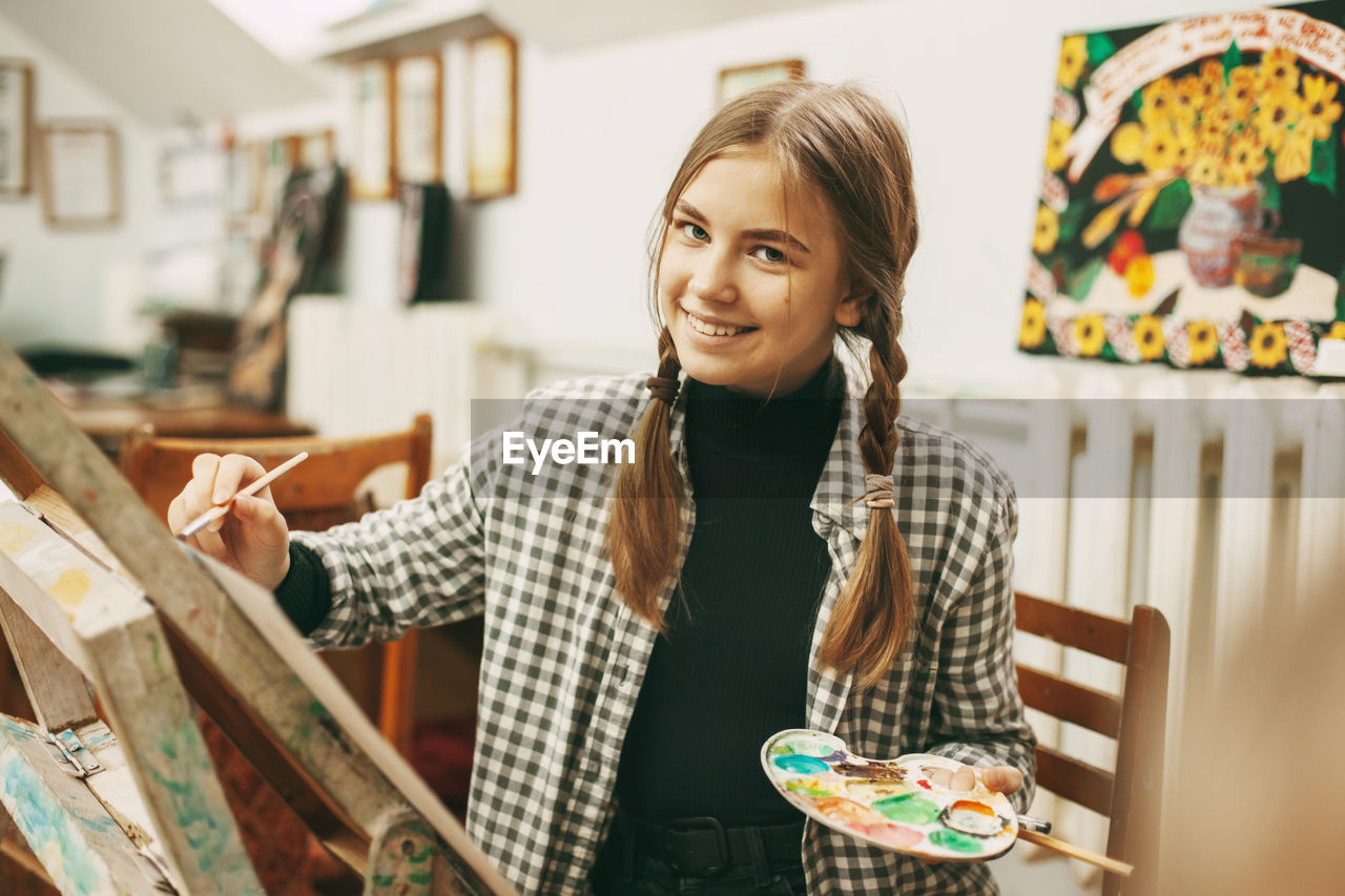 Portrait of girl painting at classroom