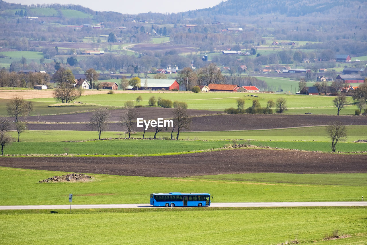 Bus traveling on a country road in a rural landscape