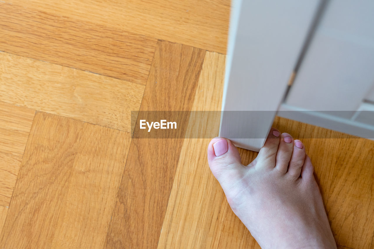 floor, flooring, hardwood floor, one person, wood, indoors, home interior, hand, lifestyles, adult, hardwood, domestic life, laminate flooring, high angle view, wood flooring, domestic room, parquet floor, wood stain, close-up, cleaning, human leg, human foot, women, limb, personal perspective