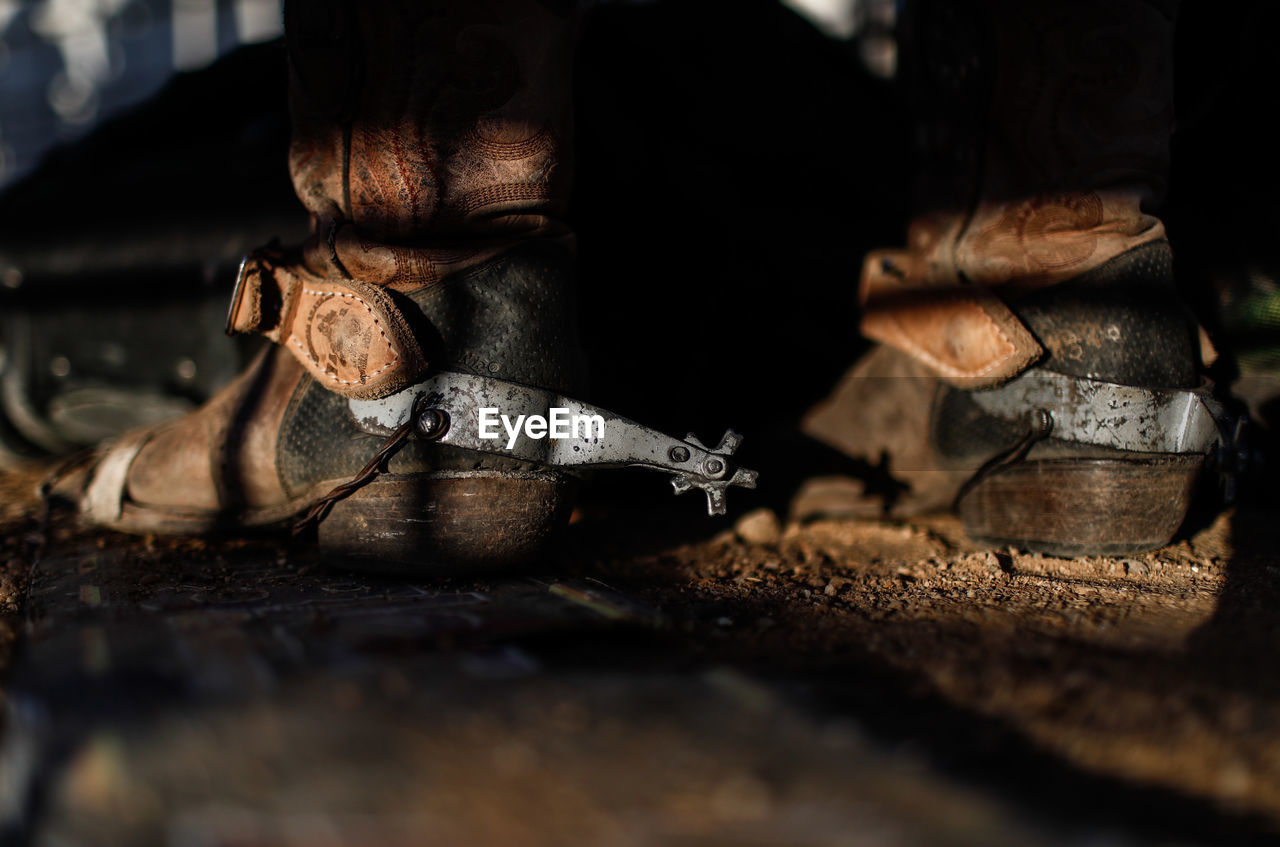 Close-up of shoes on dirt road