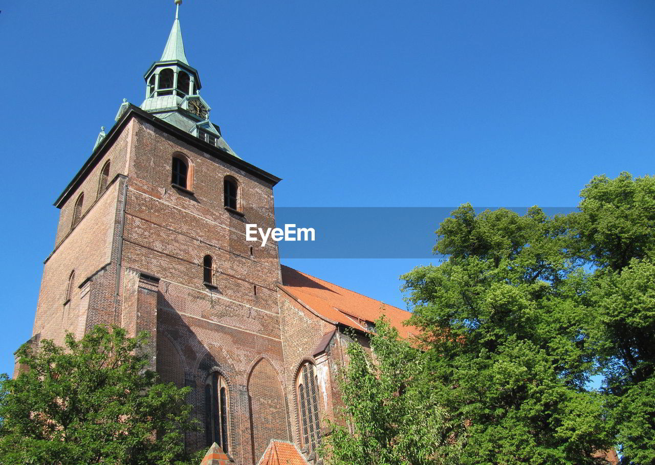 Low angle view of bell tower against blue sky