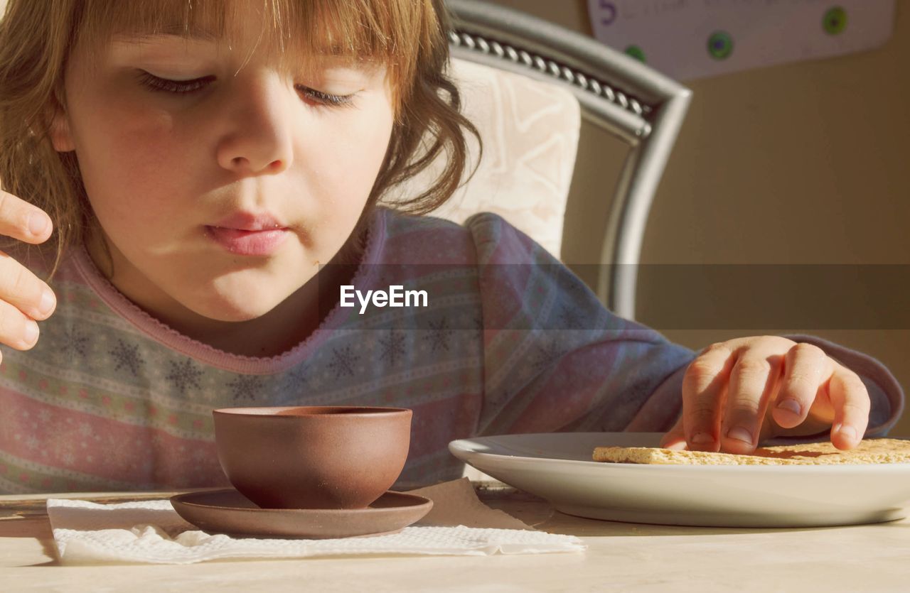 PORTRAIT OF A GIRL SITTING WITH FOOD