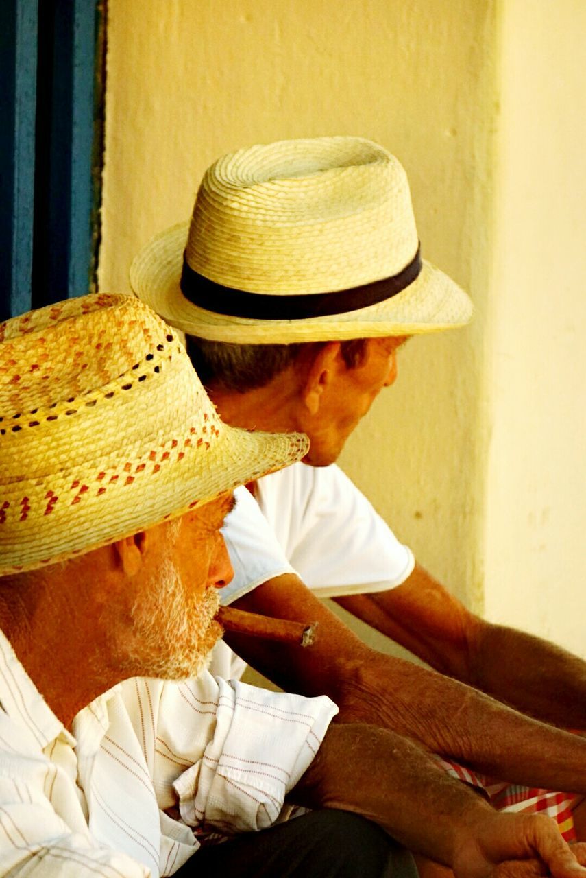 MIDSECTION OF MAN SITTING ON HAT