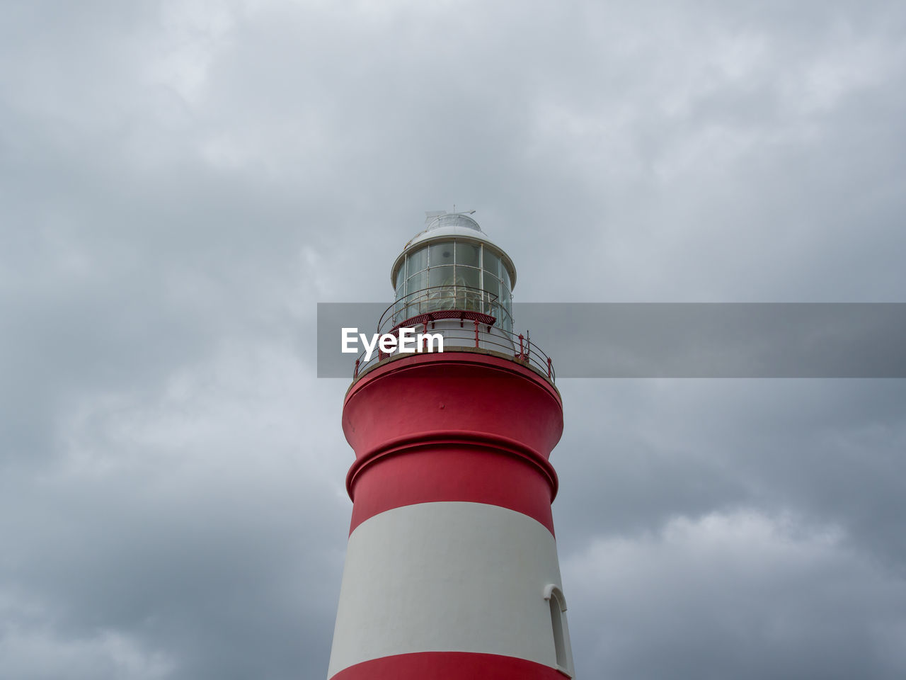 Low angle view of cape agulhas lighthouse against dramatic dark sky, south africa