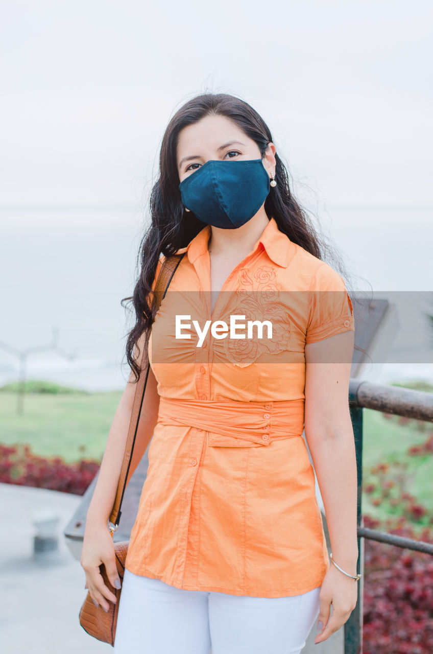 Young woman wearing mask standing outdoors