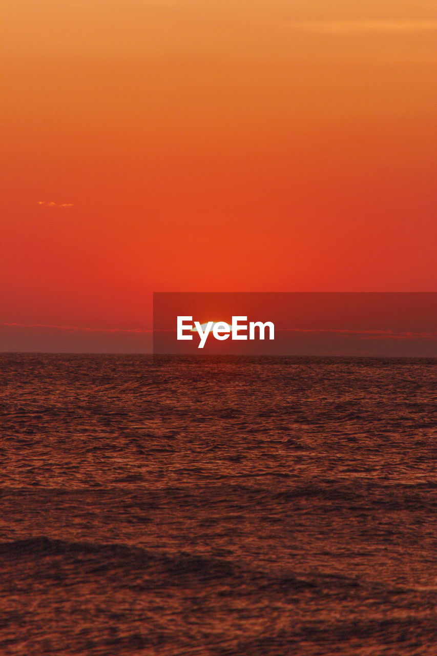 SCENIC VIEW OF SEA AGAINST ORANGE SUNSET SKY