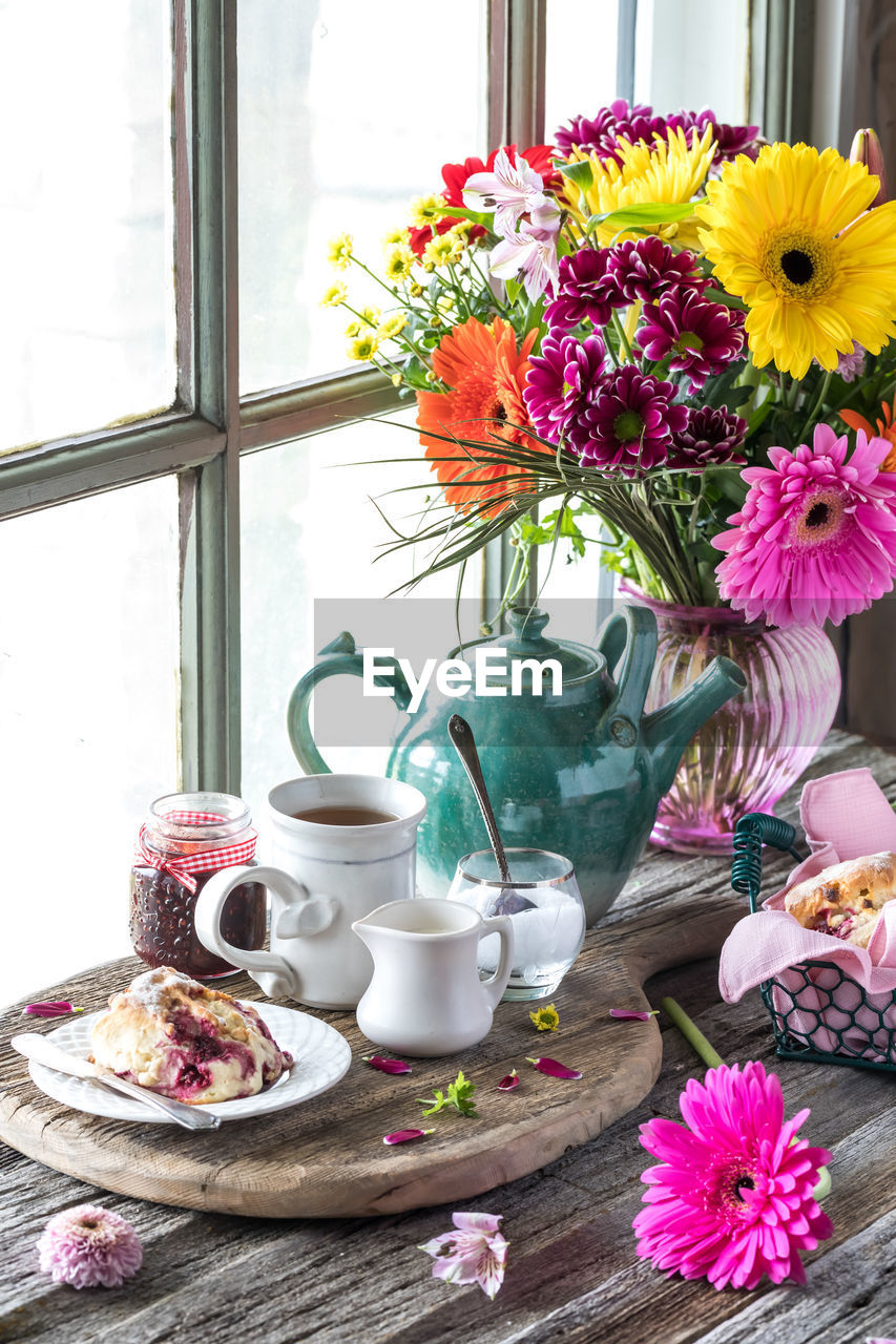 A beautiful arrangement including tea and fixings, scones and flowers.