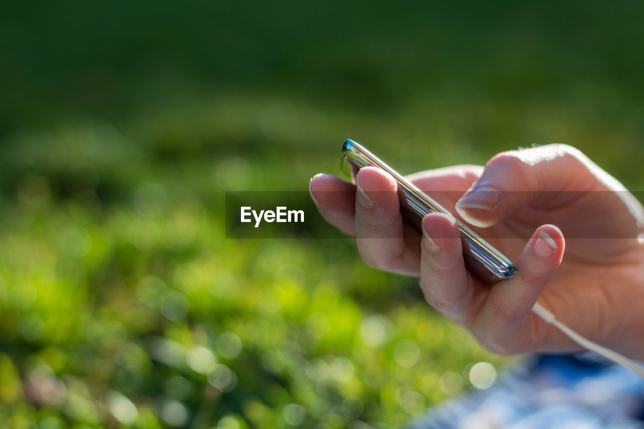 Cropped hand of person holding mp3 player 