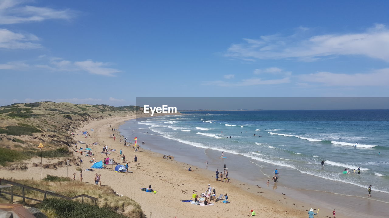 People at beach against sky