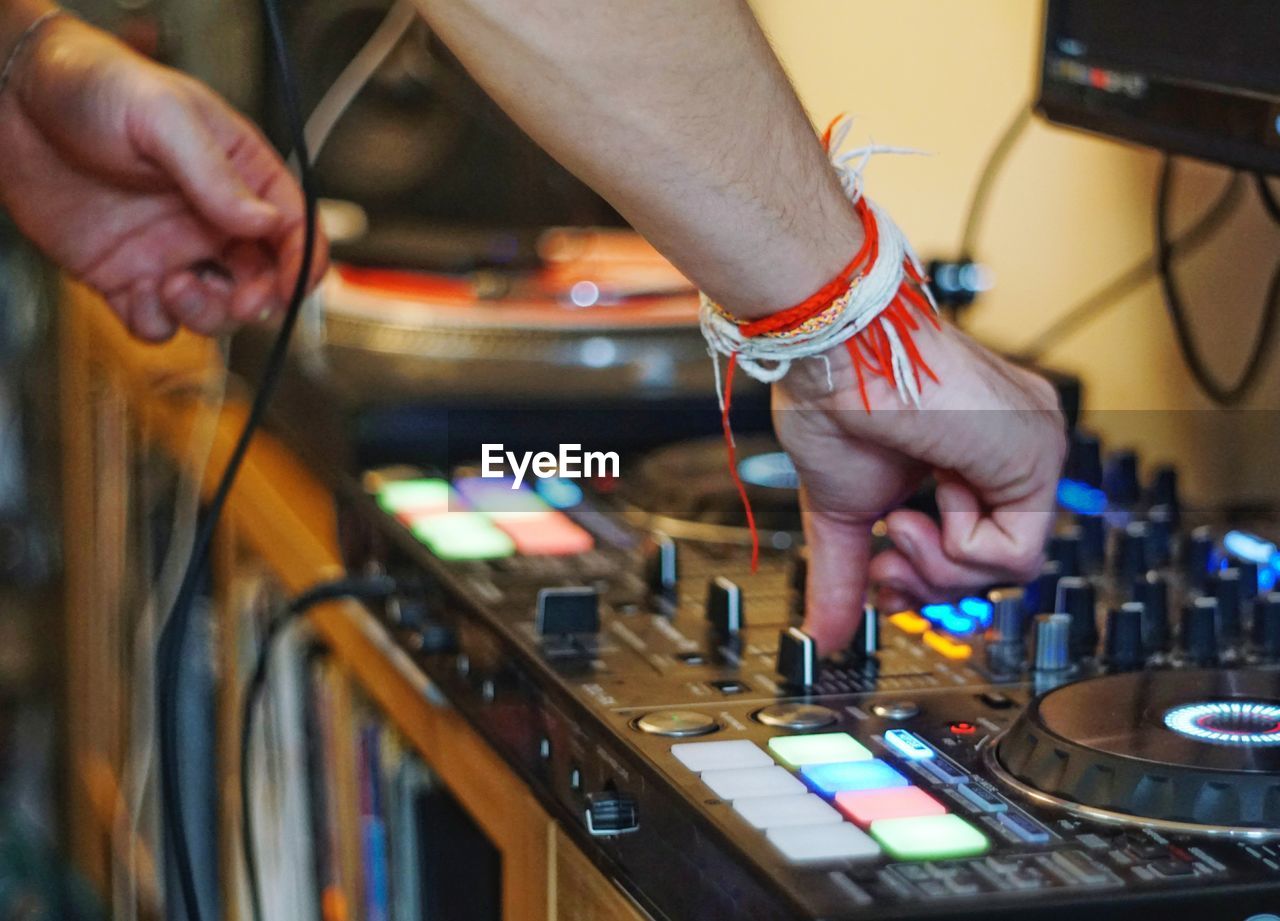 Cropped hand of man mixing music at recording studio