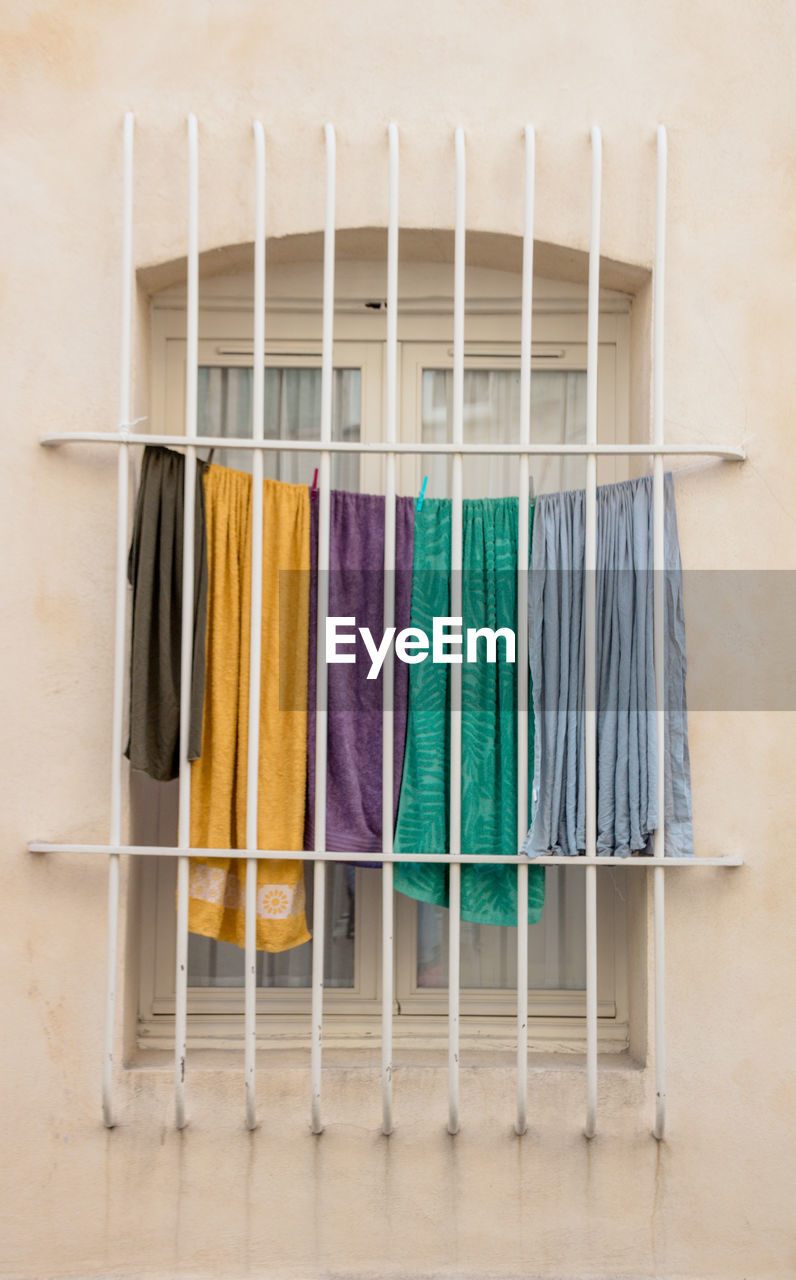 Close-up of multi colored clothes over behind bars