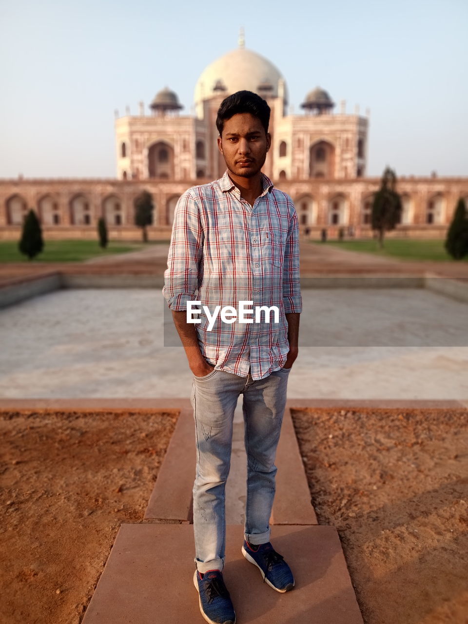 Full length portrait of man standing against historical building