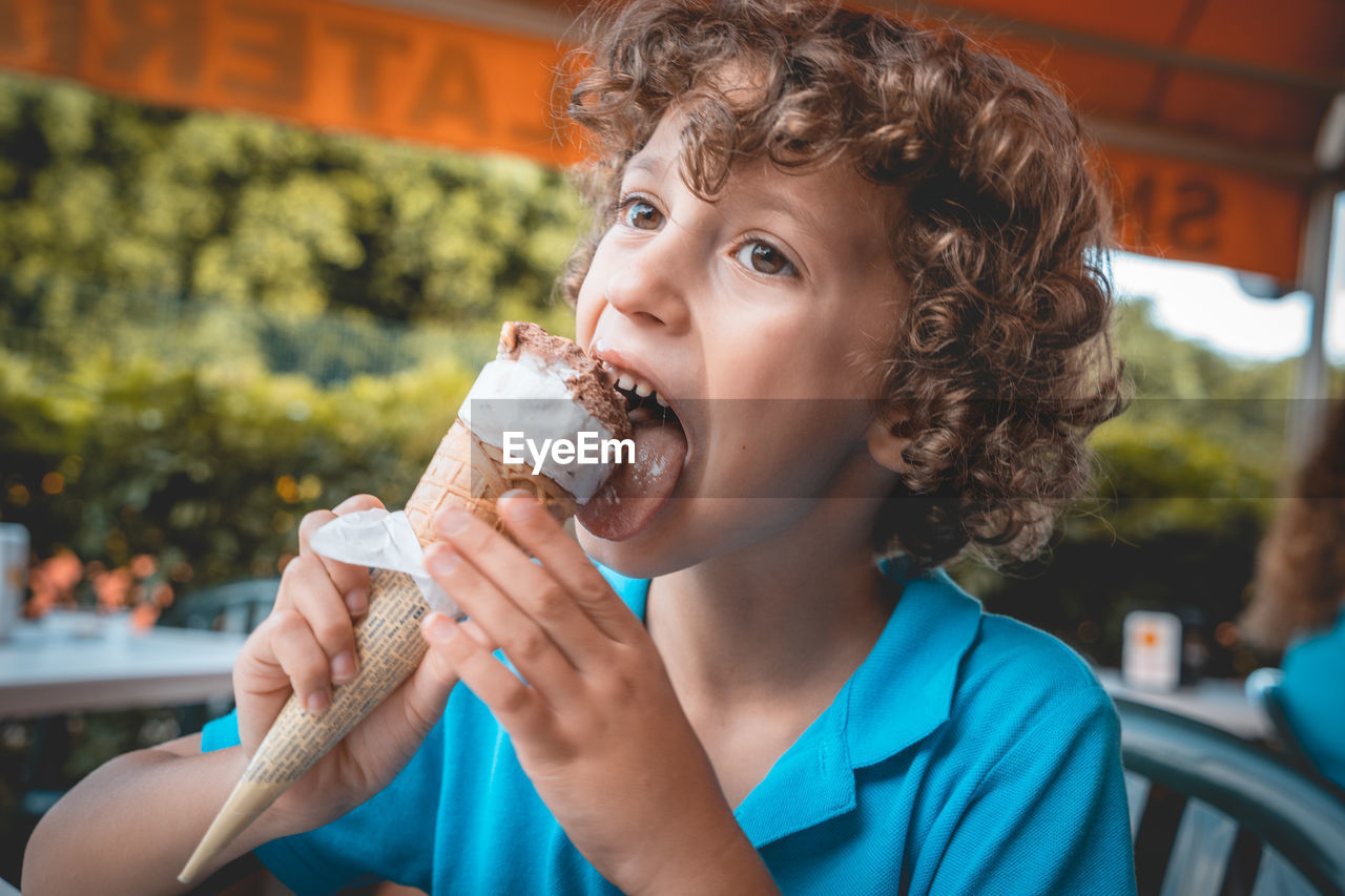 Boy licking ice cream in restaurant
