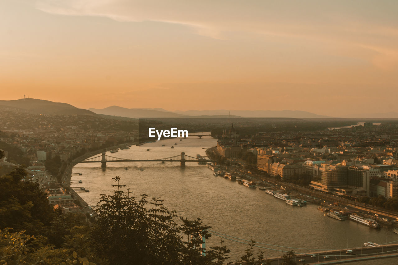 HIGH ANGLE VIEW OF RIVER AMIDST CITY AGAINST SKY