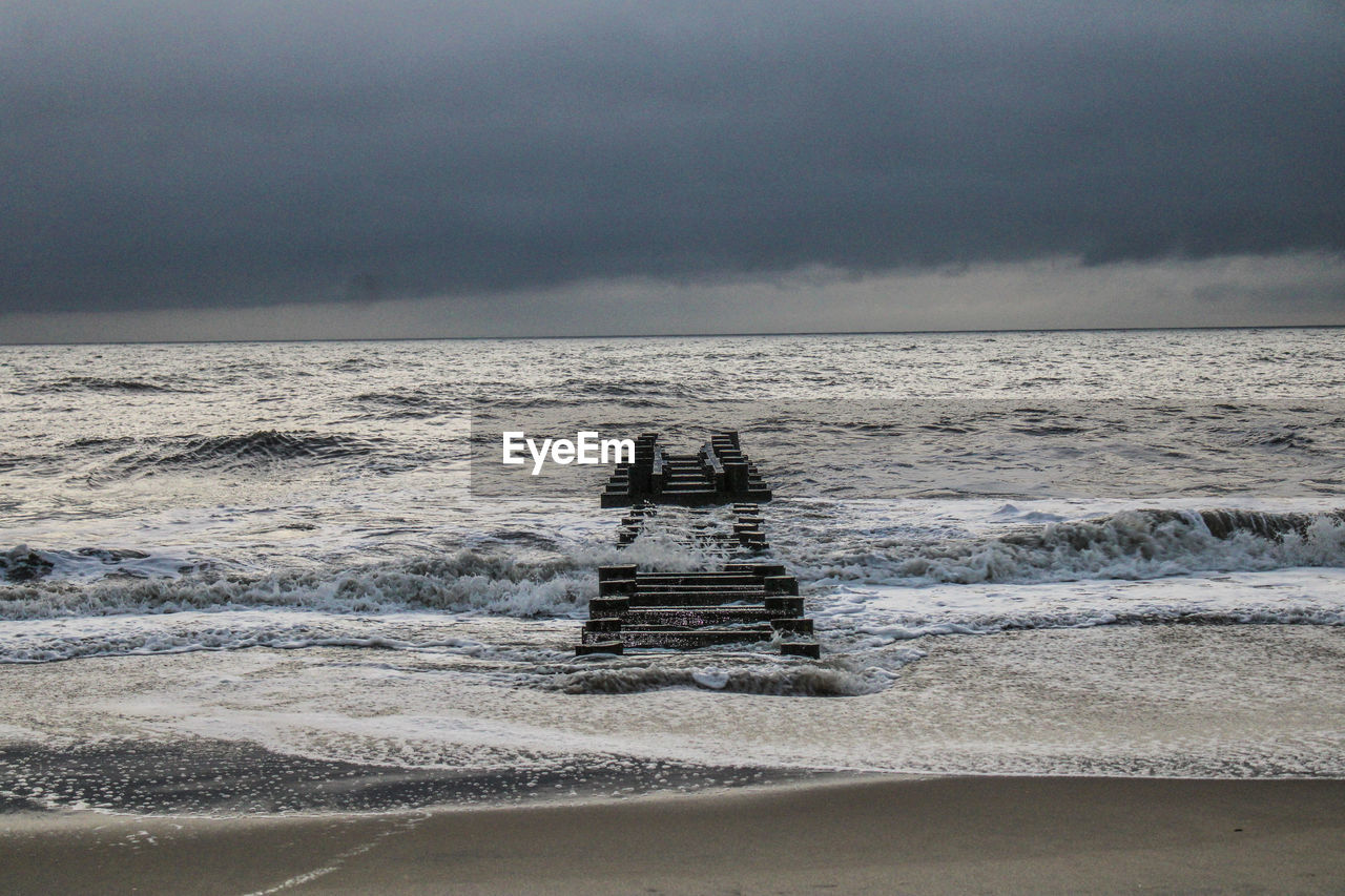 LIFEGUARD HUT ON SEA SHORE AGAINST SKY