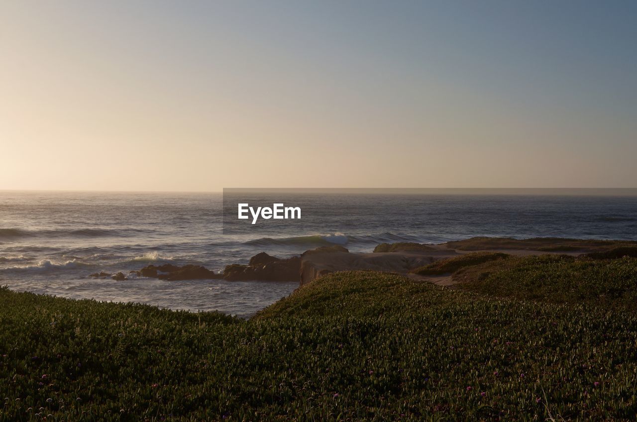 Scenic view of sea against clear sky during sunset