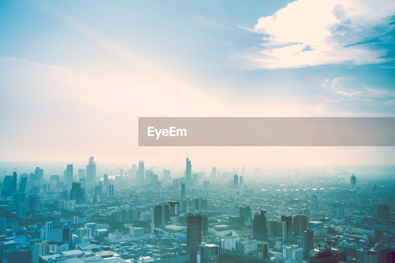 Aerial view of buildings in city against sky