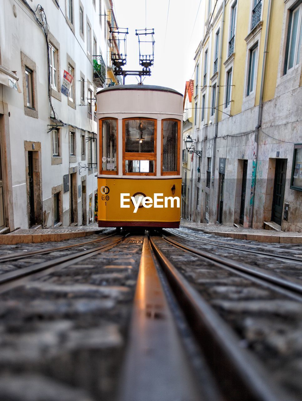 TRAIN ON RAILROAD TRACKS BY BUILDINGS