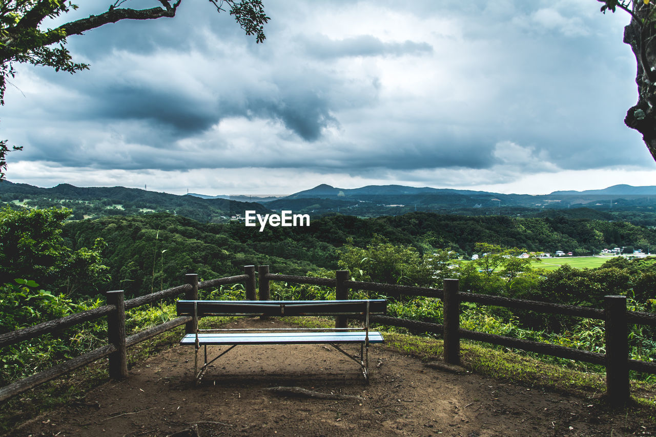 Empty bench overlooking countryside landscape