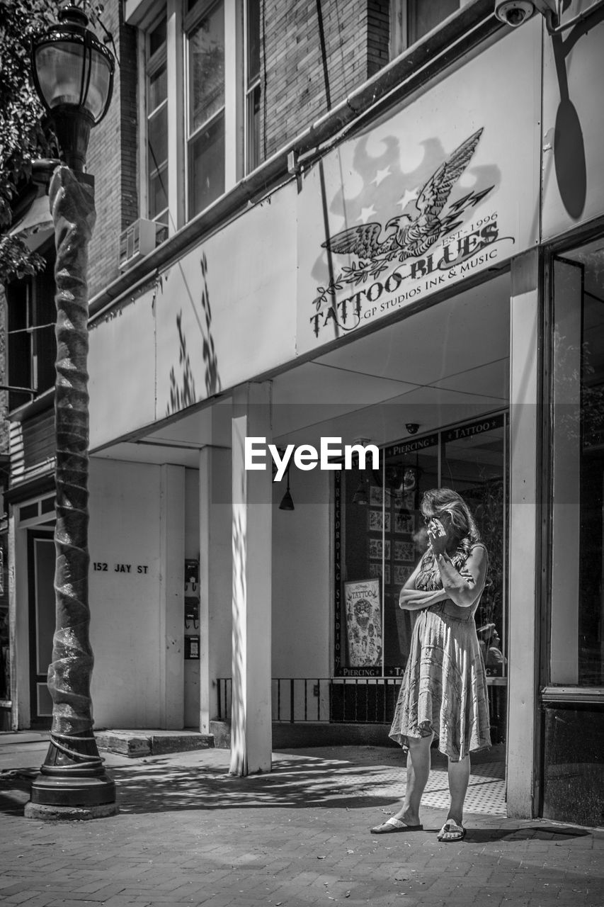 WOMAN STANDING AGAINST BUILDING