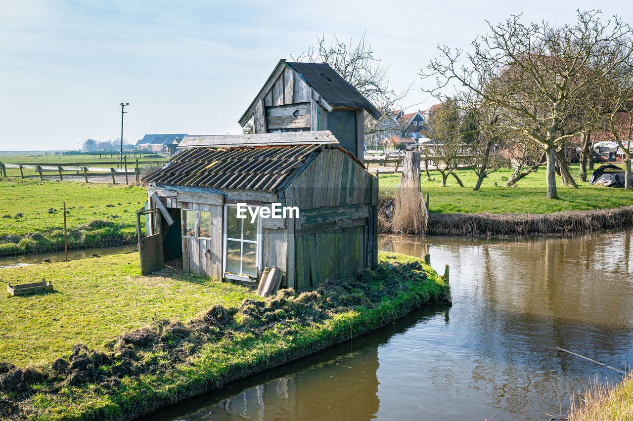 Old wooden shed along the waterside on a sunny spring day