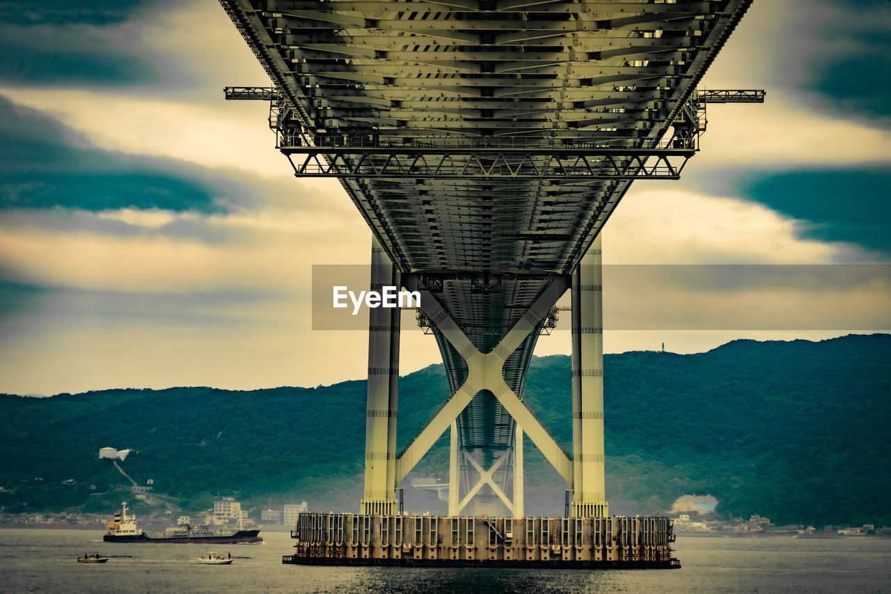 low angle view of bridge against cloudy sky