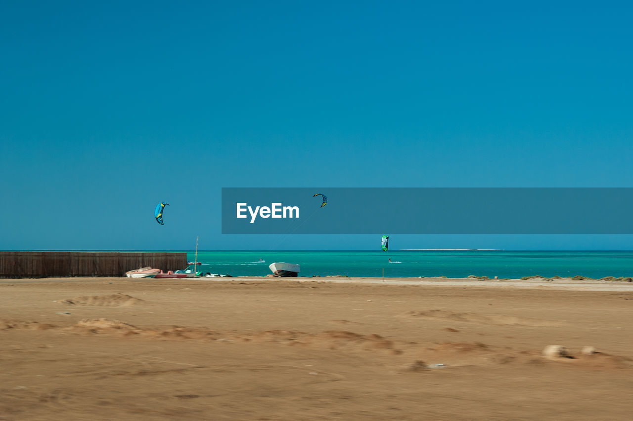 SCENIC VIEW OF BEACH AGAINST BLUE SKY