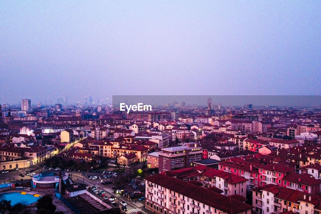 HIGH ANGLE VIEW OF BUILDINGS IN CITY AGAINST CLEAR SKY