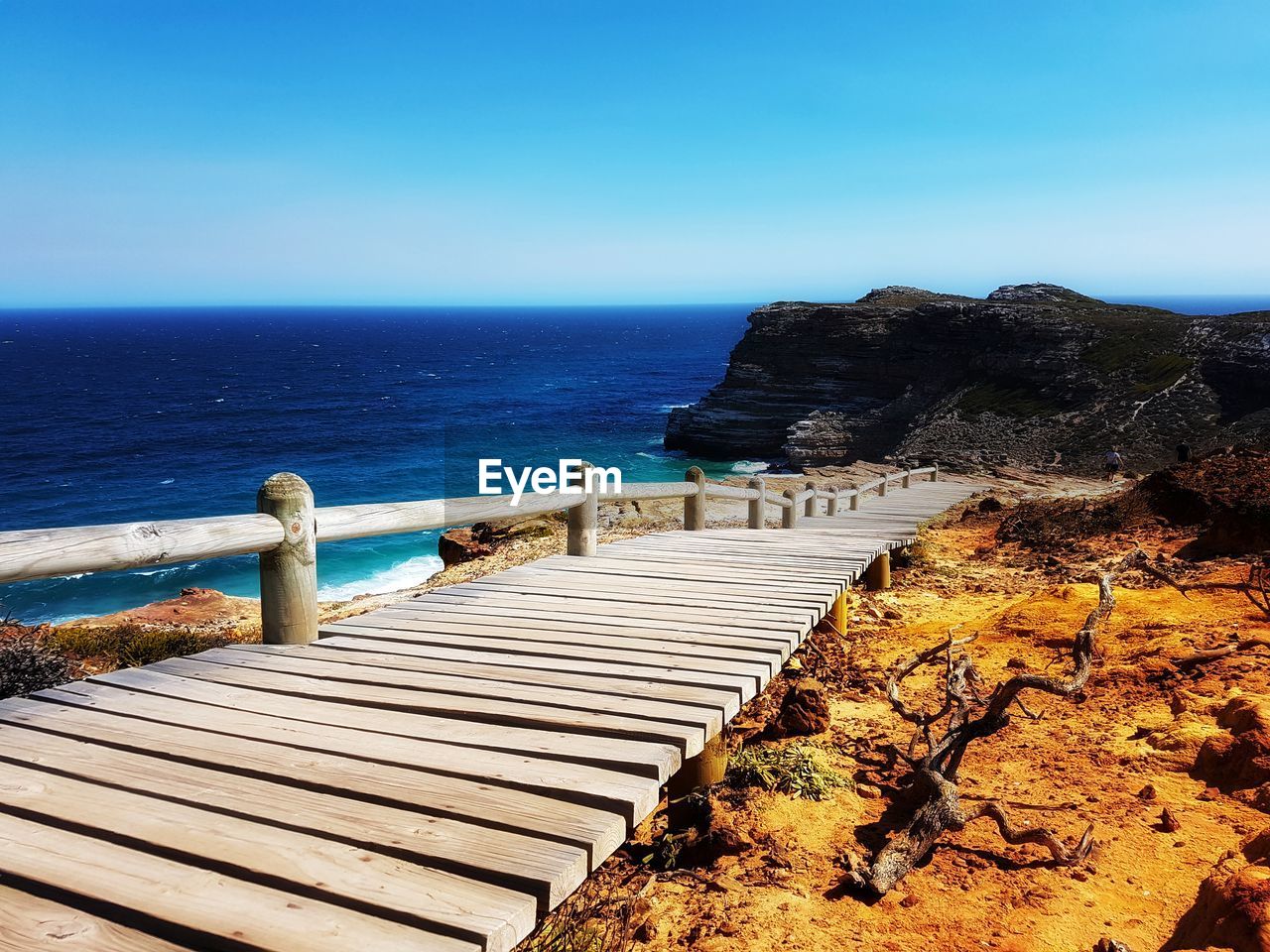 SEA BY CLIFF AGAINST CLEAR BLUE SKY