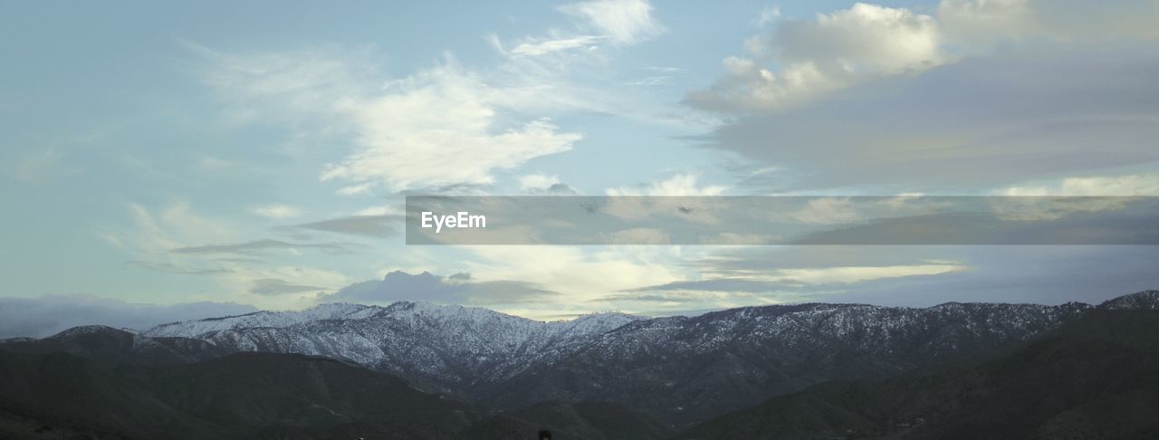 Scenic view of mountains against cloudy sky