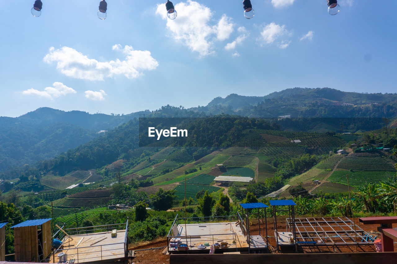 Scenic view of townscape and mountains against sky
