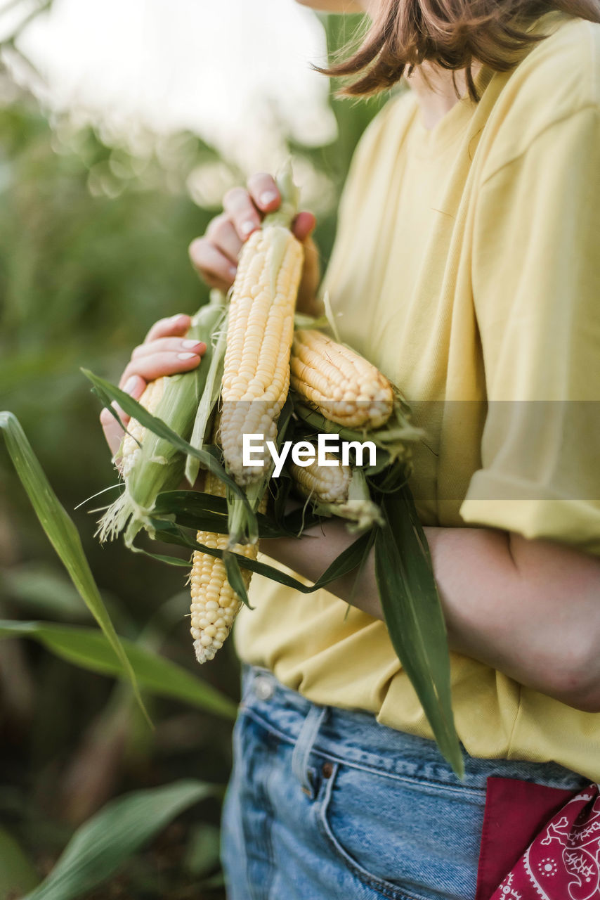 Midsection of woman holding corns