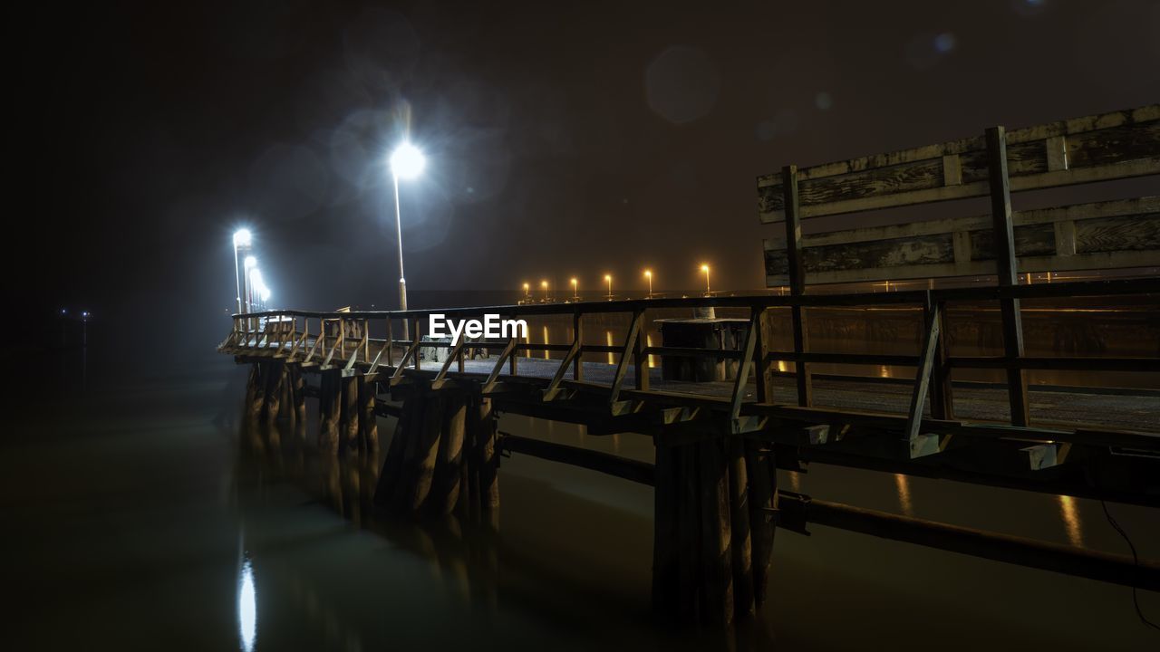 View of pier in canal at night