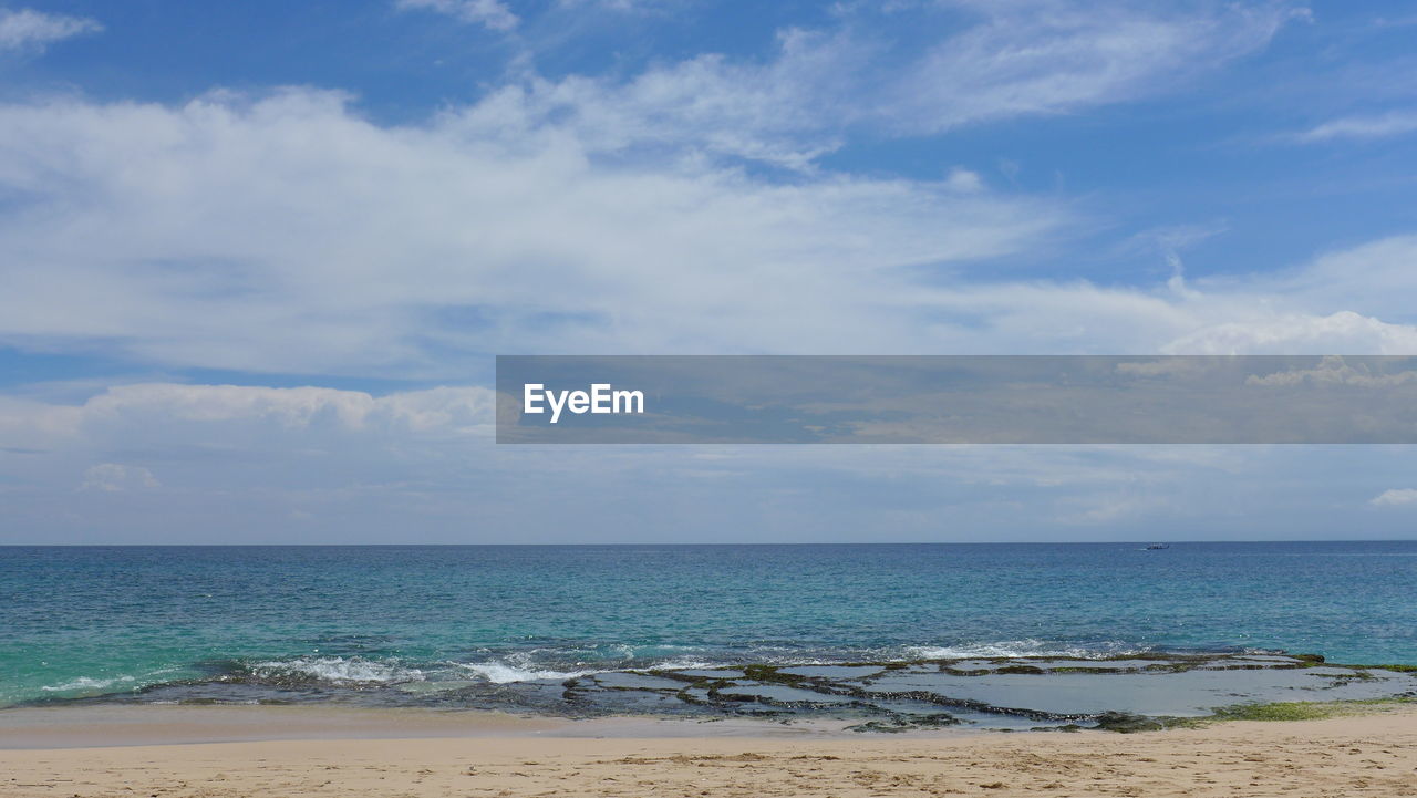 View of calm beach against blue sky